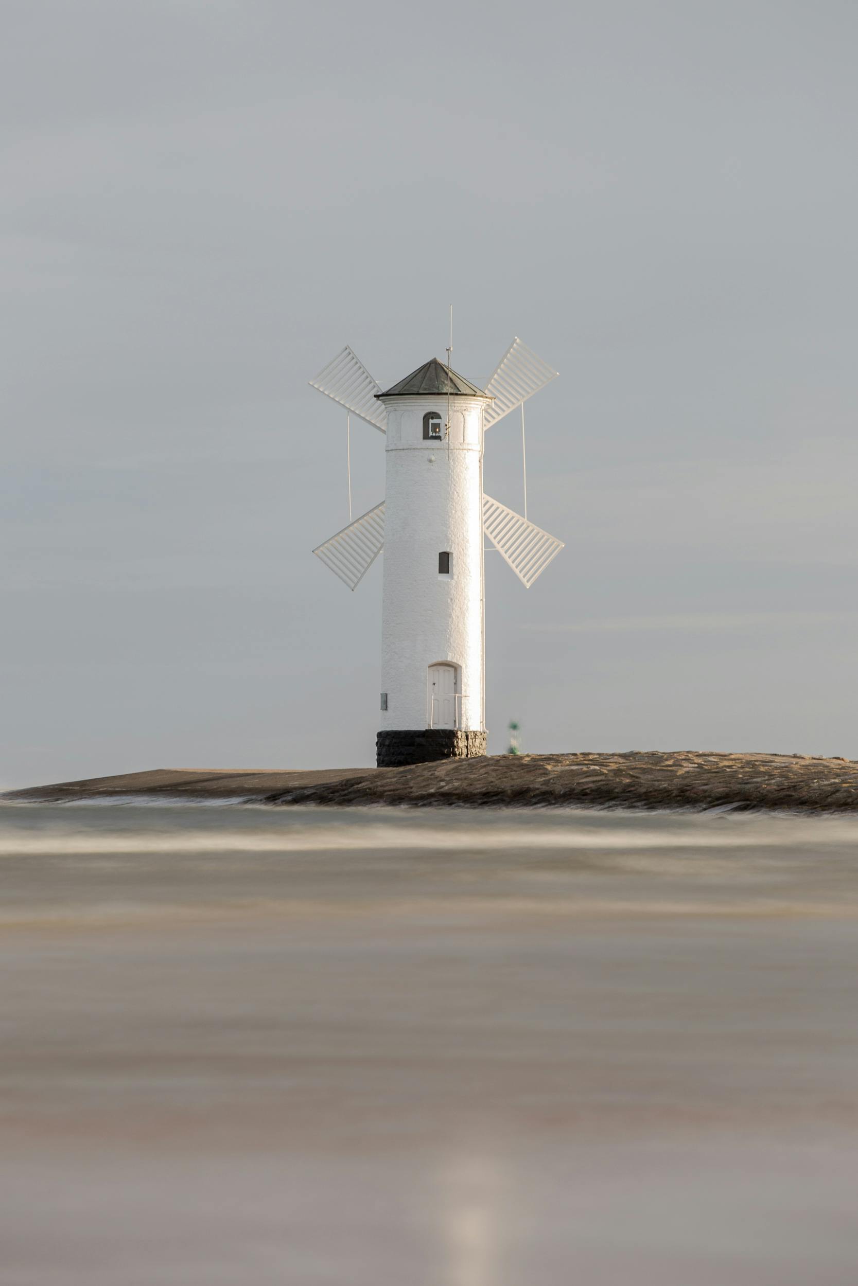 Resources Serene view of Stawa Młyny lighthouse on the coast of Świnoujście, Poland, during a tranquil day.