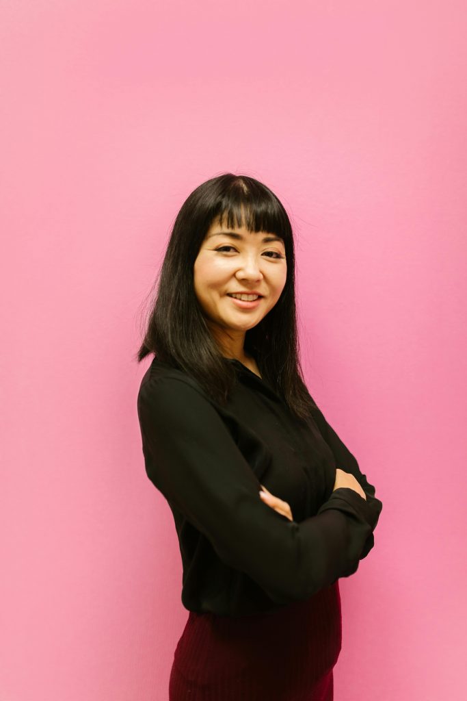 Smiling woman in business attire posing confidently arms crossed.